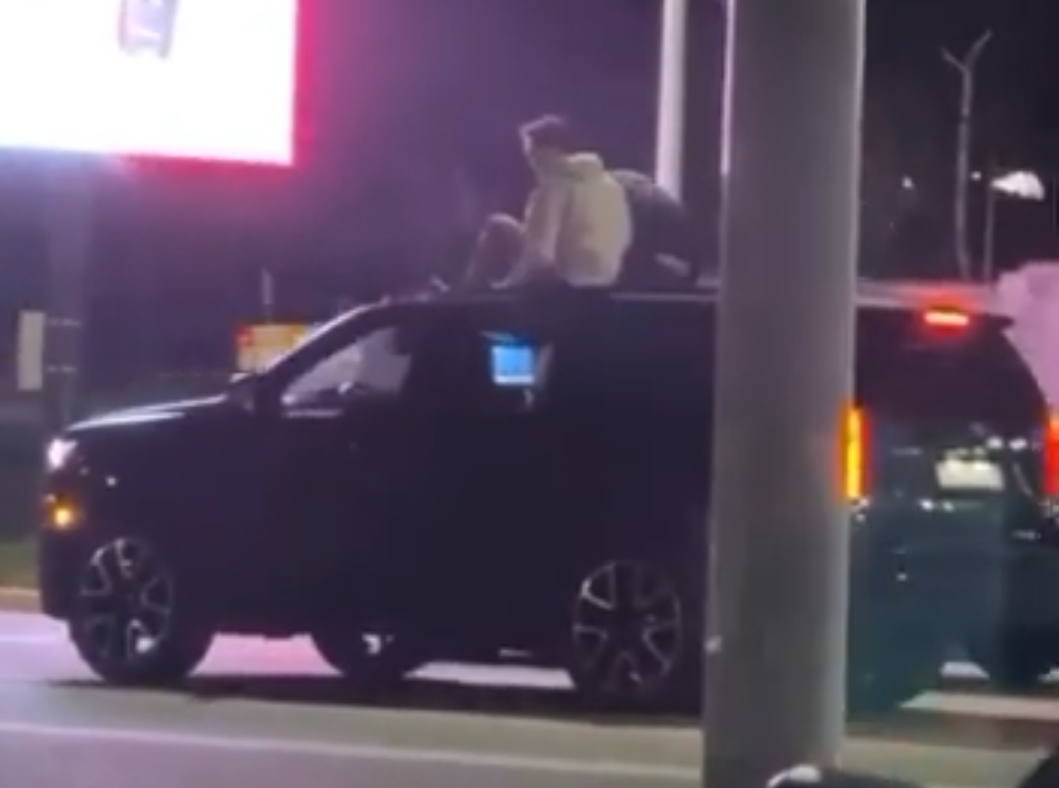 Алматыда жол ортасында тұрған автокөліктің төбесіндегі жігіттер түсірілді